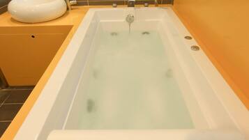 A bathtub with a white sink and a faucet.