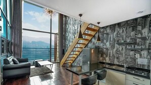 Una cocina moderna con escalera de madera, zona de bar y vistas a las montañas.