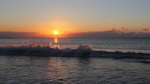 A sunset over the ocean with waves crashing onto the shore. - Neulpureun Pension (Yeongdeok)
