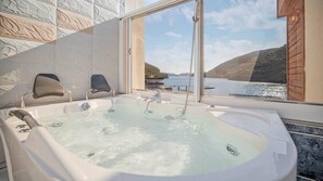 A hot tub with a view of a lake and hills. - Dream Pension (Tongyeong)