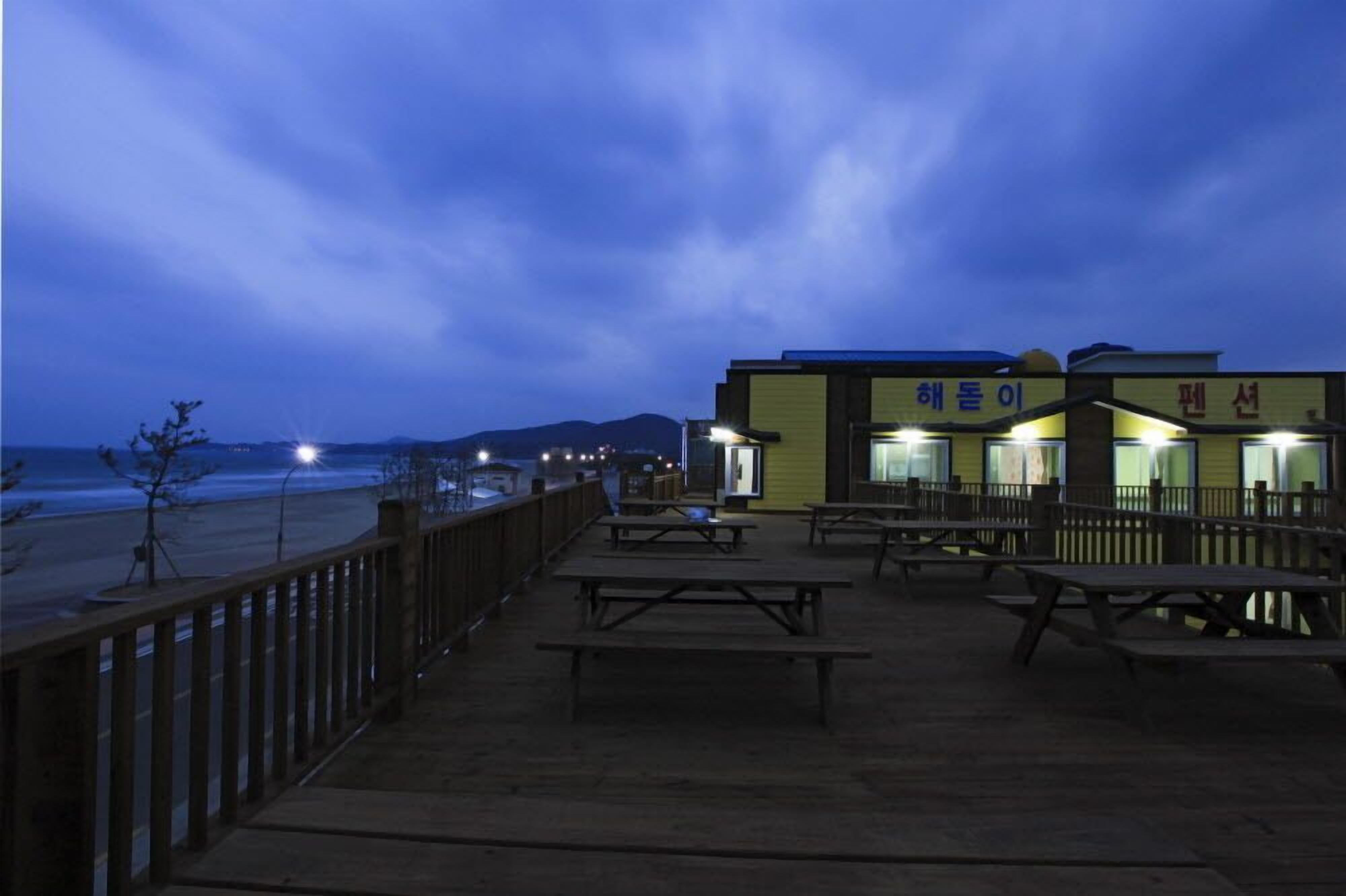 A beachside restaurant with outdoor seating and a view of the ocean.