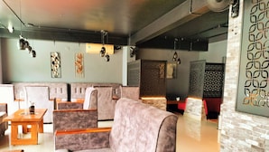 A modern interior with a seating area featuring cushioned sofas and wooden tables. - Hotel Bright Heritage (Kochi)