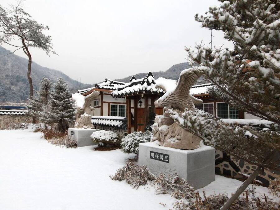 Un edificio tradicional con techo nevado y una estatua en su fachada.