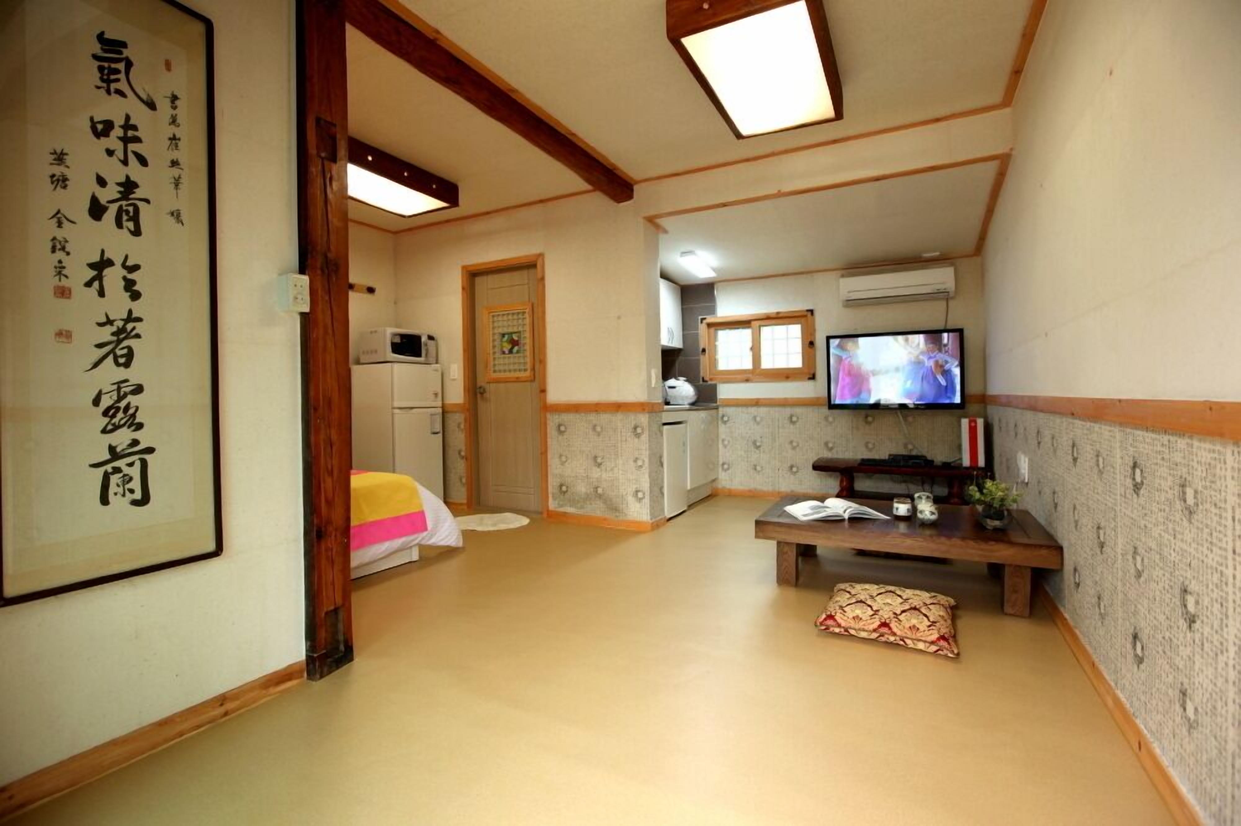 A traditional Japanese-style room with tatami flooring, a low table, and a television.