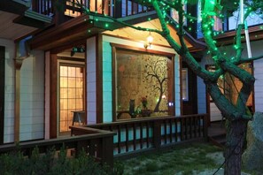 A cozy building with a wooden facade, a welcoming entrance, and a window decorated with a tree and cat motif. - Lebois Pension (Gapyeong)