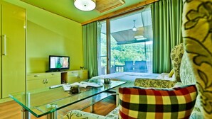 A room with a glass table, a television, and a view of greenery outside. - Sambatgol Pension (Pocheon)