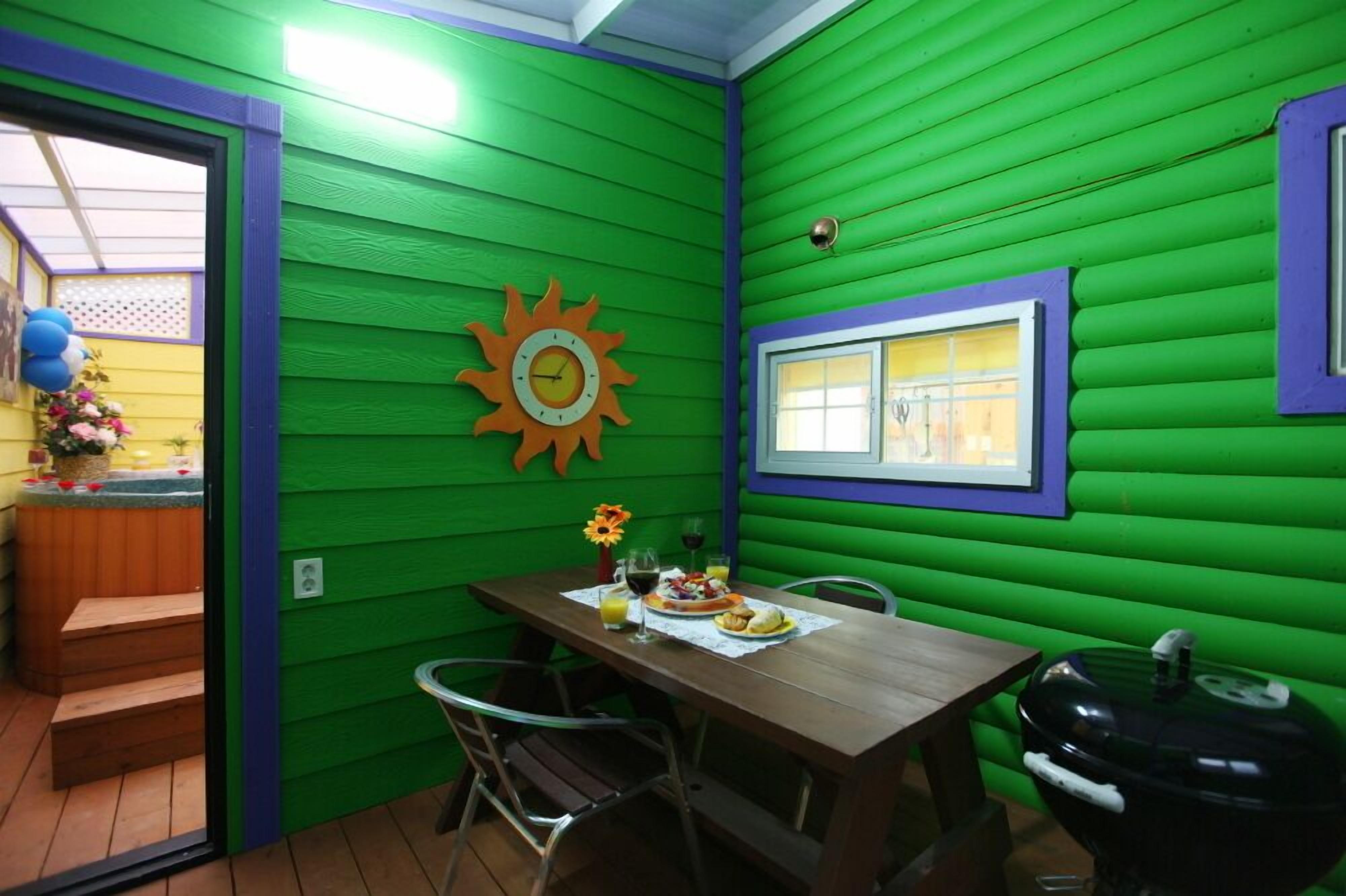 A dining area with a wooden table and chairs, a grill, and a window with a view.