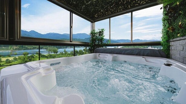 A hot tub with a view of a lake and mountains. - Milky Way Pension (Gapyeong)