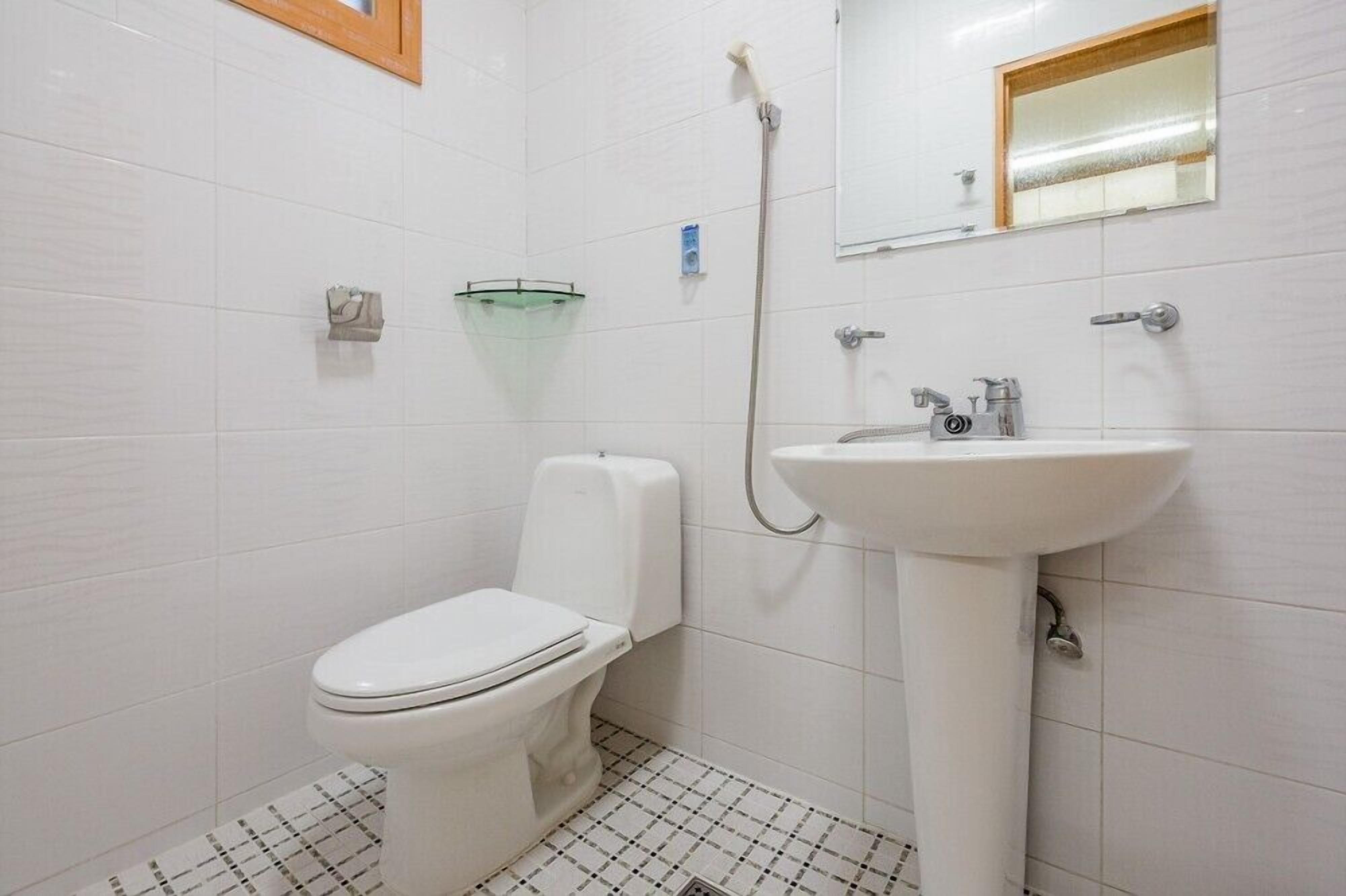 A bathroom with a toilet, sink, and shower.