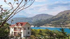 A two-story building with balconies, overlooking a coastal area with mountains in the background. - Geoje Cheongsol Pension (Geoje)