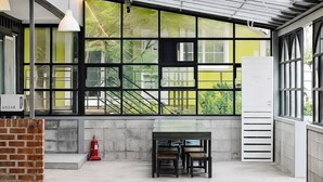 Un interior moderno con ventanas amplias, piso de concreto y extintor.