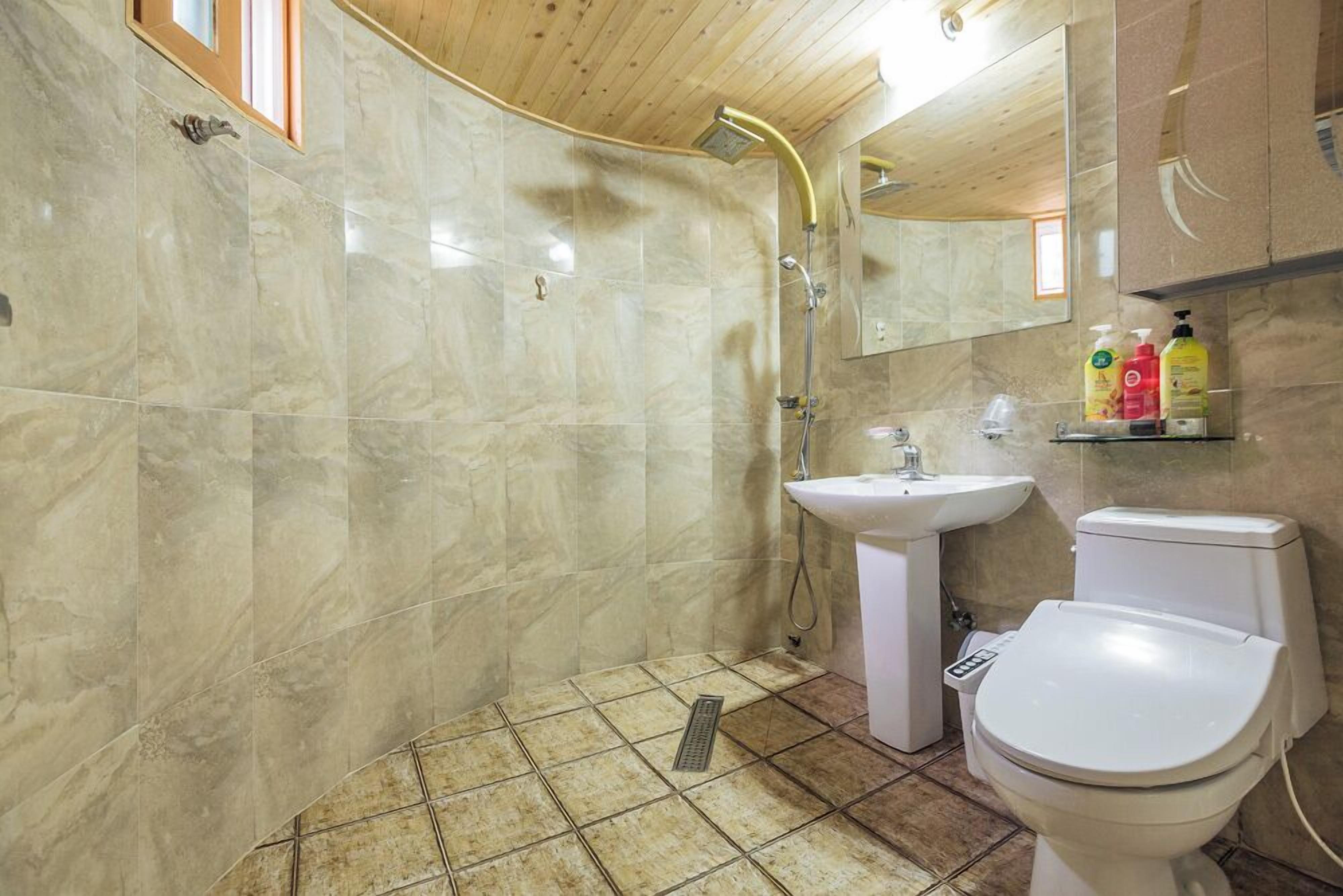 Un bagno con doccia, lavandino e WC.
