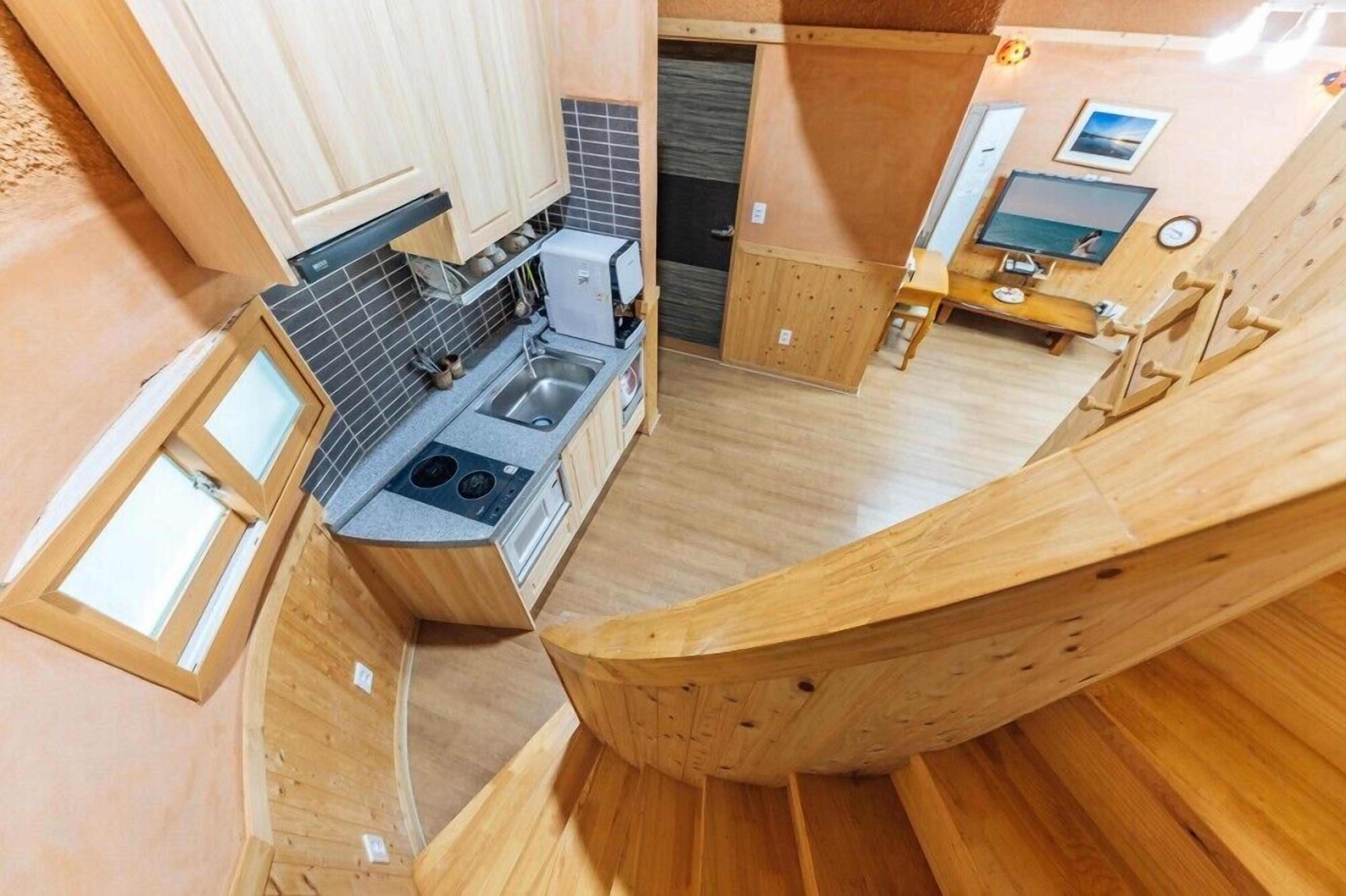 A compact kitchen with a built-in stove, sink, and a small dining area with a table and chairs.