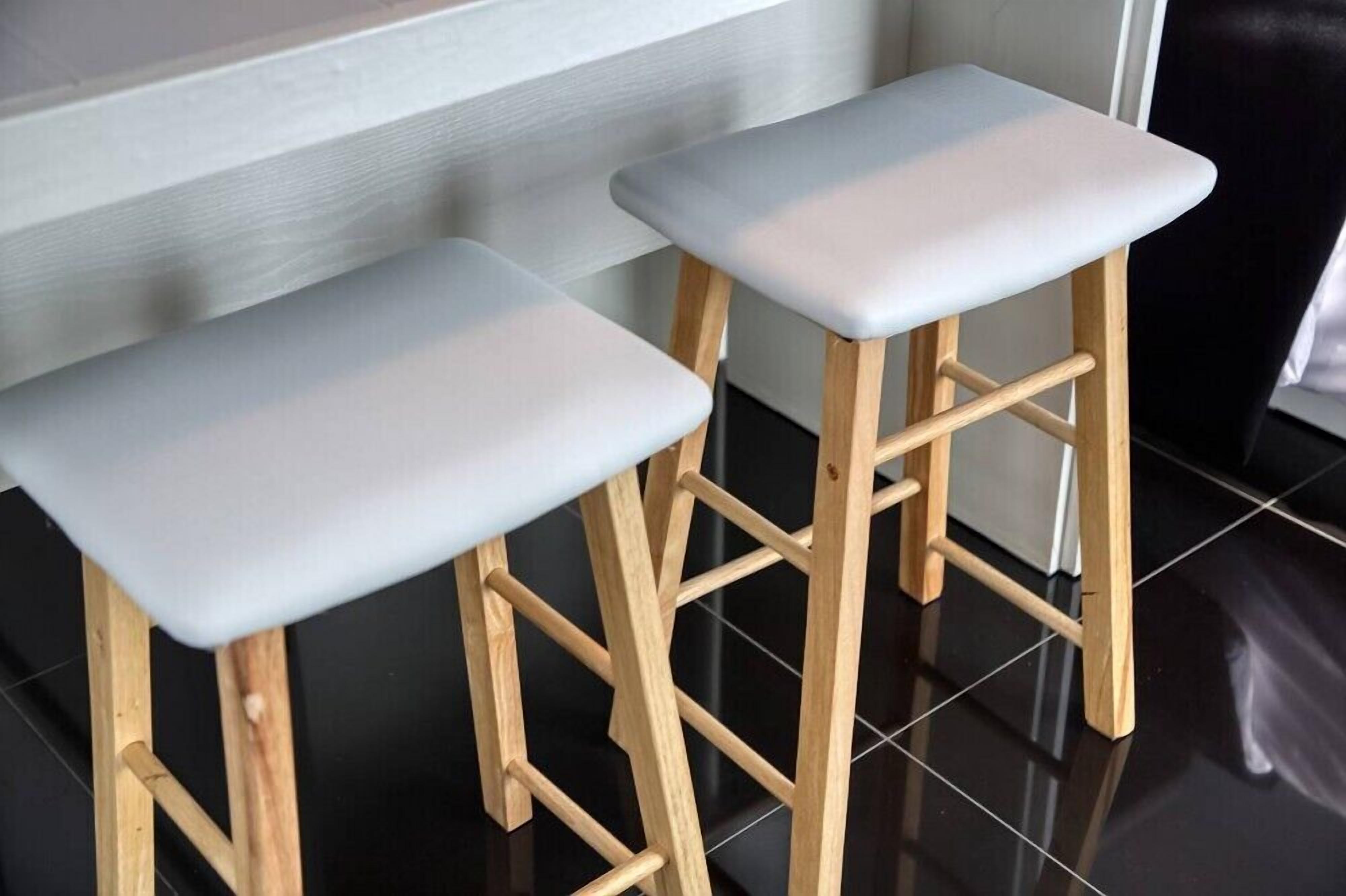 Dos taburetes de madera con asientos blancos.