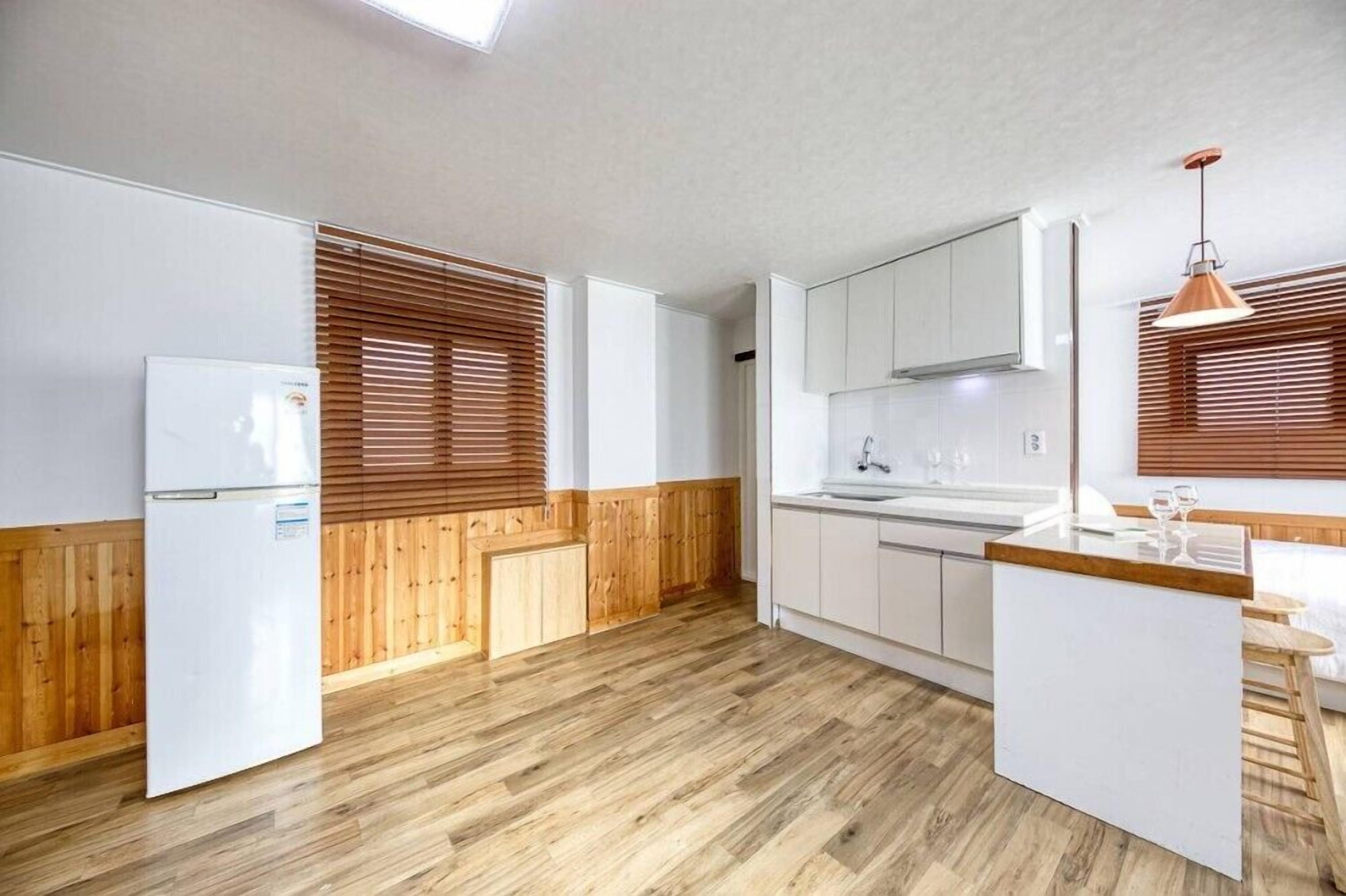 A modern kitchen with wooden accents, white cabinets, and a built-in island with seating.