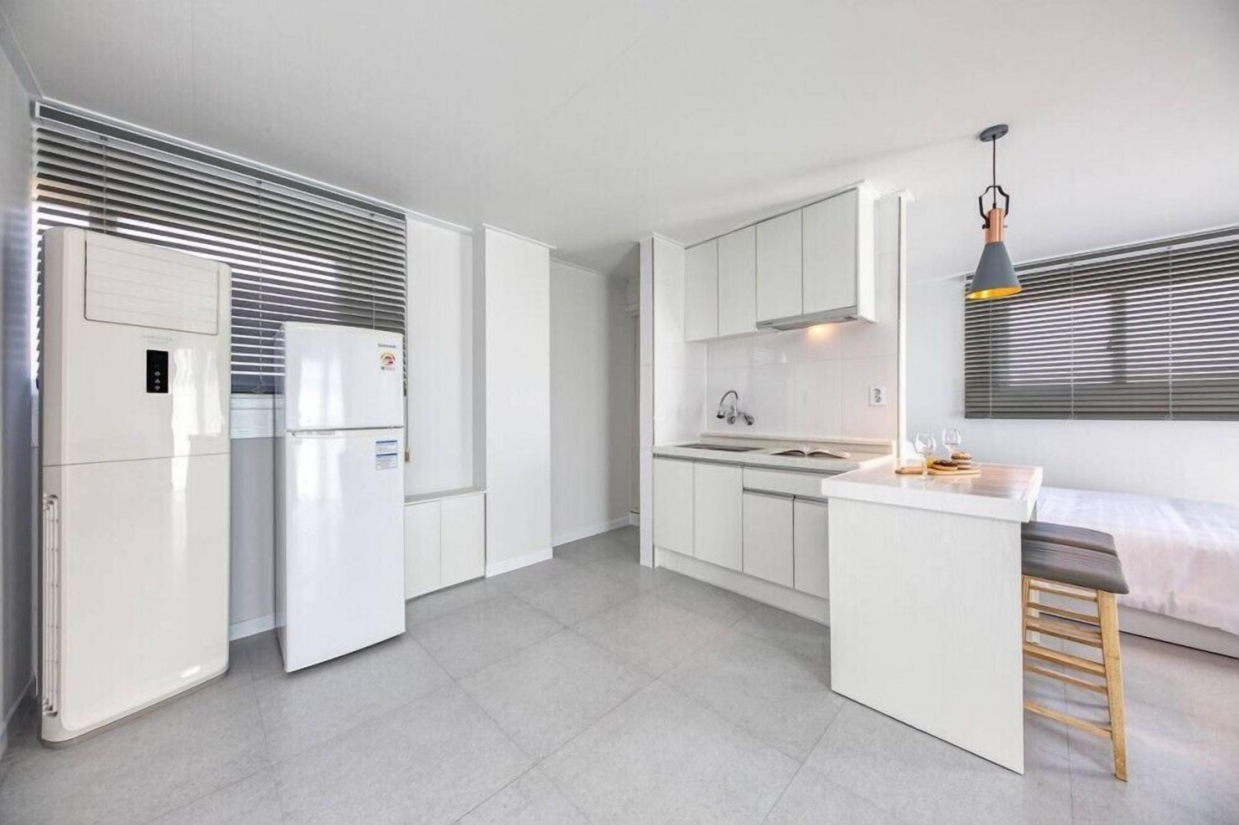 Una cocina moderna con armarios blancos, una isla central y un horno empotrado.