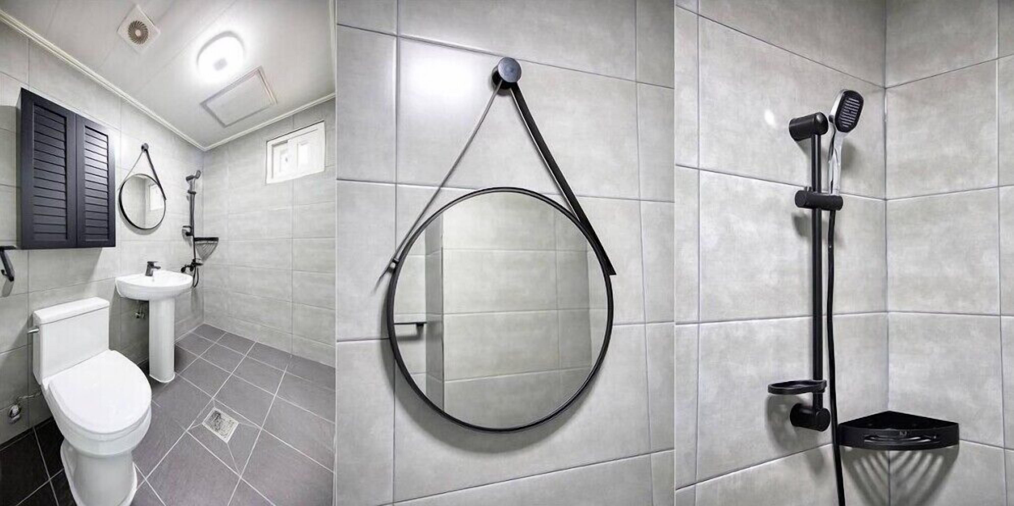 A modern bathroom with a toilet, sink, and mirror.