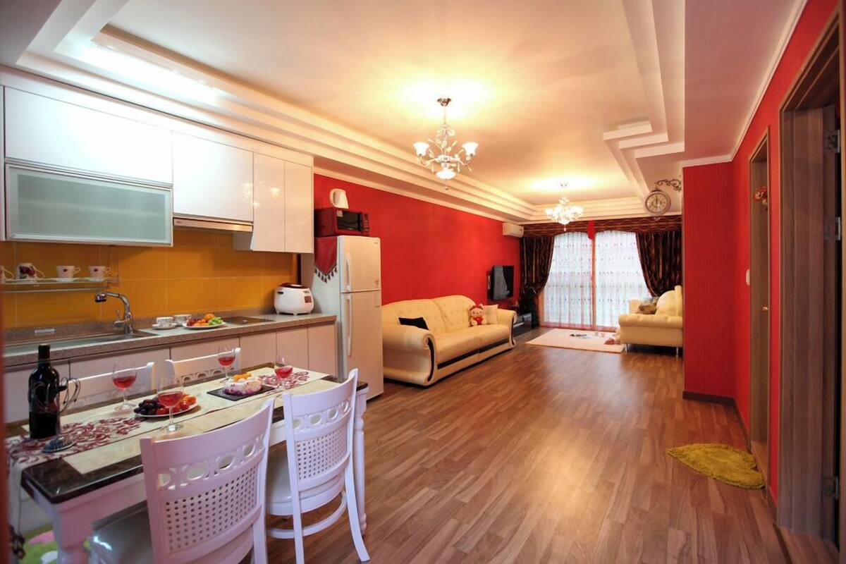 A compact living space with a kitchen, dining area, and two sofas.