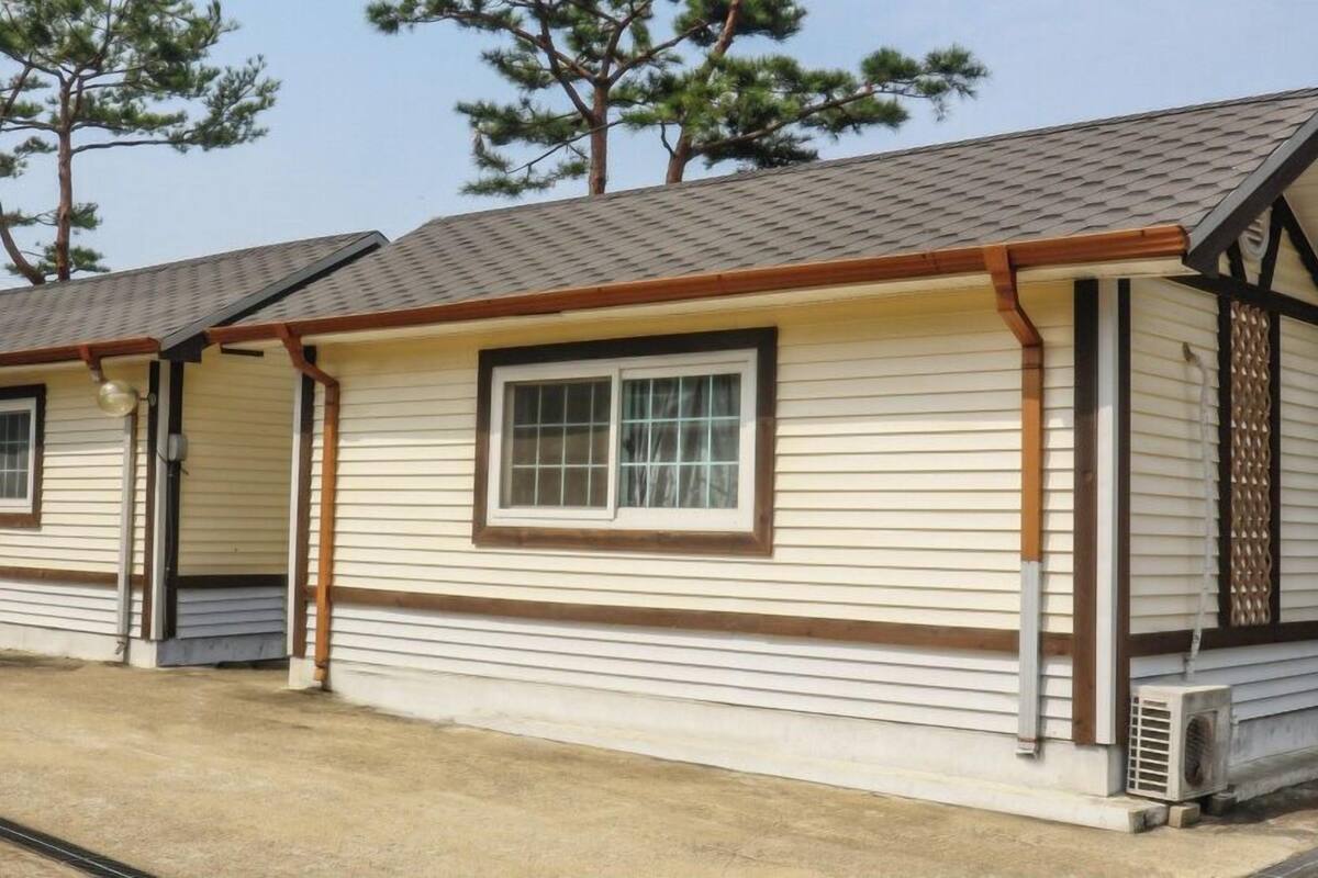 A small, single-story building with a gabled roof and a window with a grid pattern.