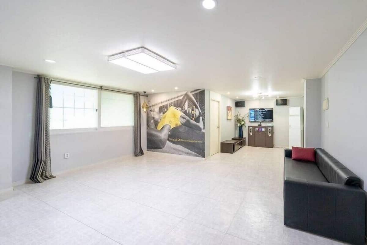 A spacious lobby with a seating area, a reception desk, and a large mural on the wall.