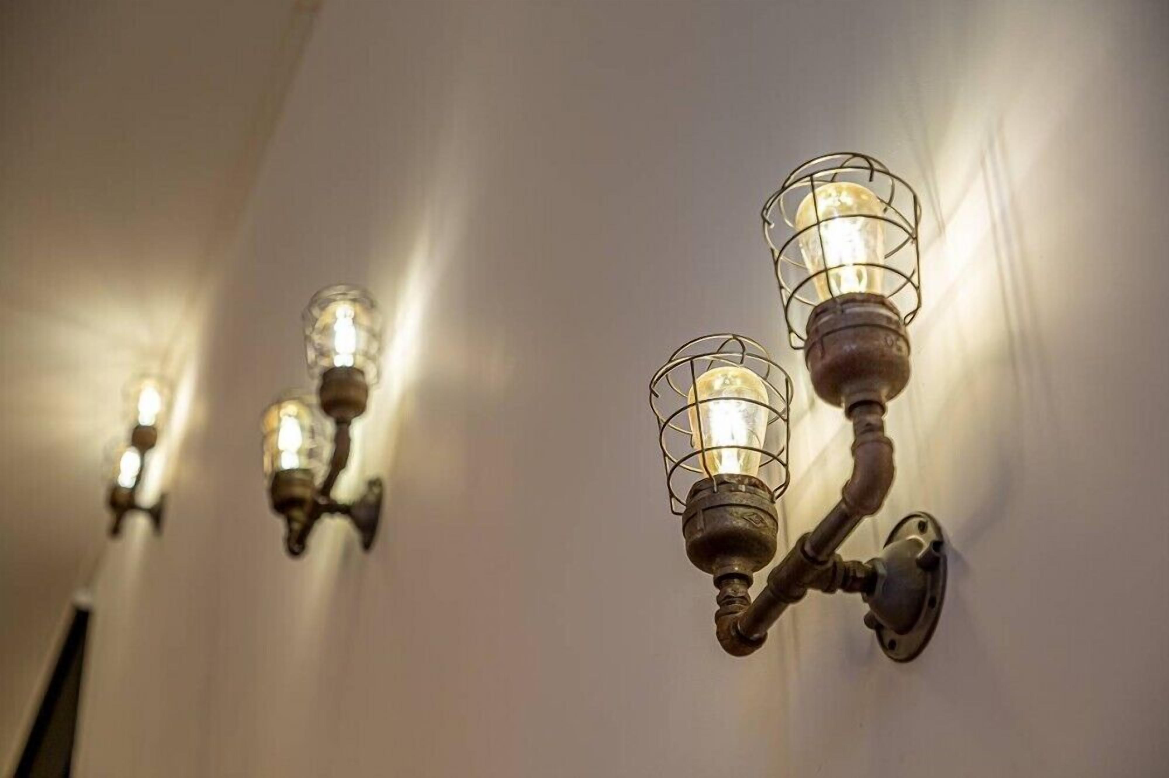 Wall-mounted sconces with exposed bulbs and metal frames.