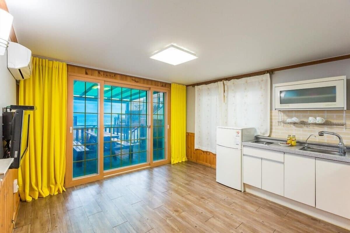 A compact kitchen with a microwave, sink, and cabinets.