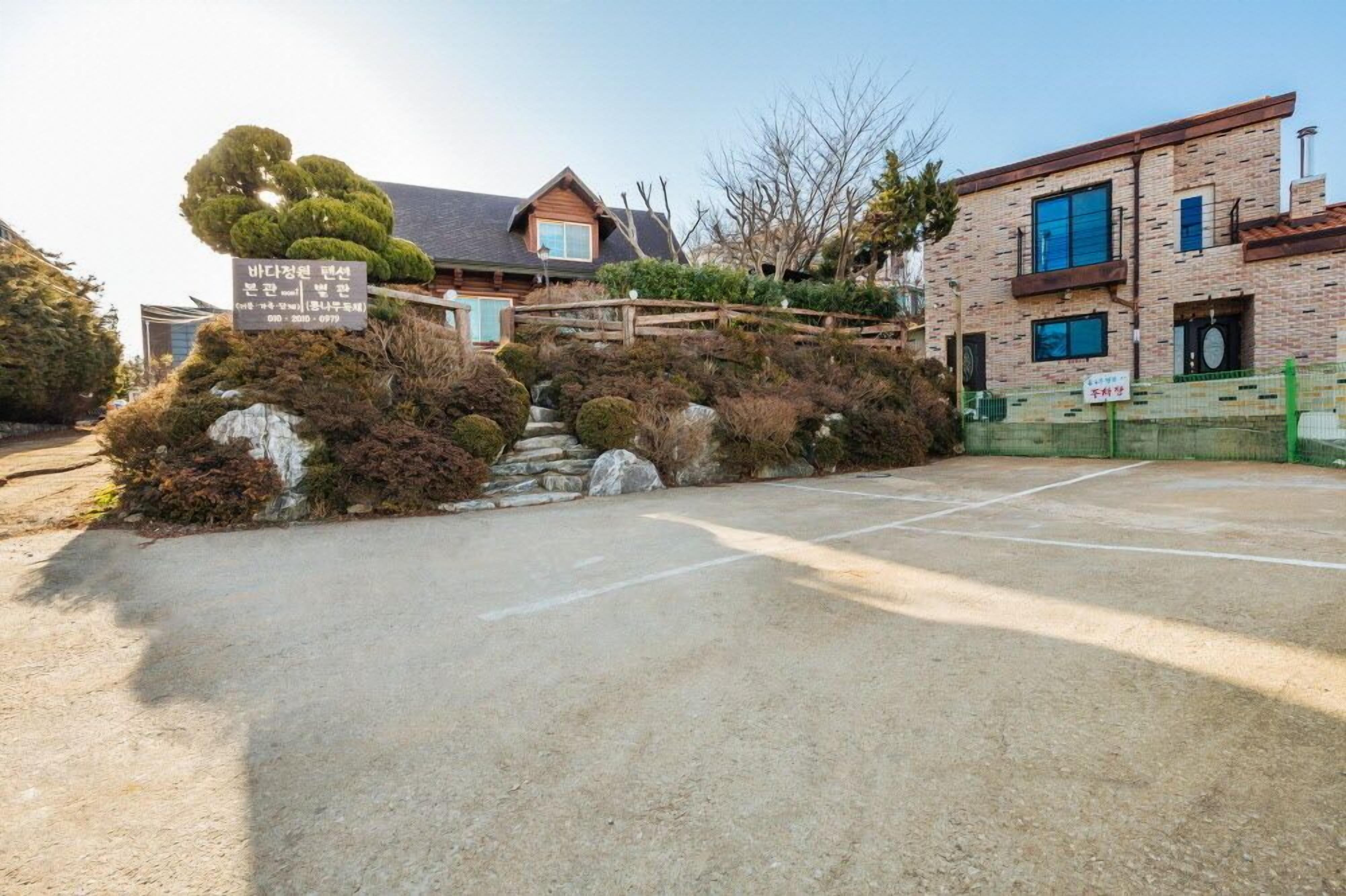 A residential building with a stone pathway leading to a wooden gate.