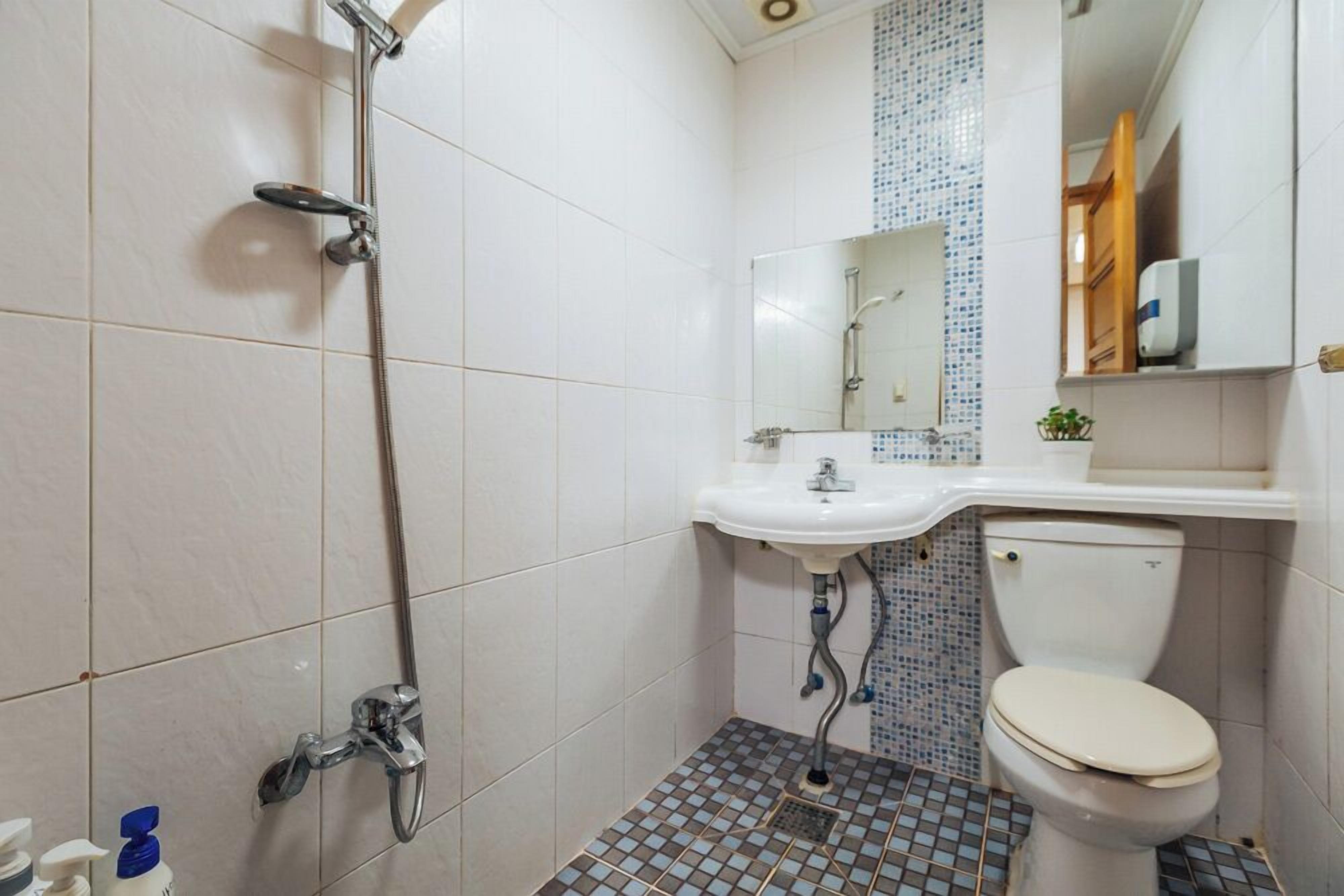 A bathroom with a shower, sink, and toilet.