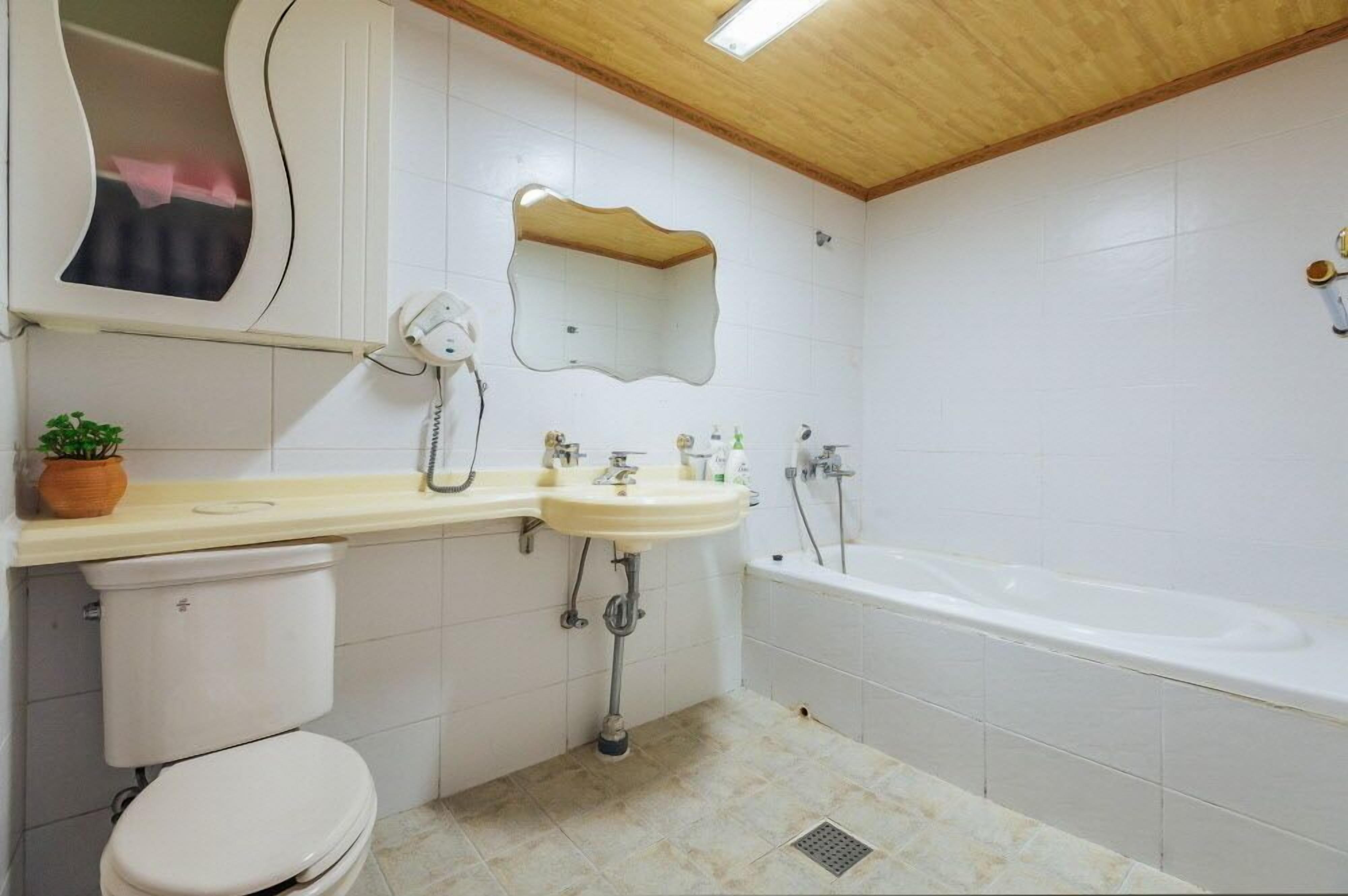 Un baño con inodoro, lavabo y bañera.
