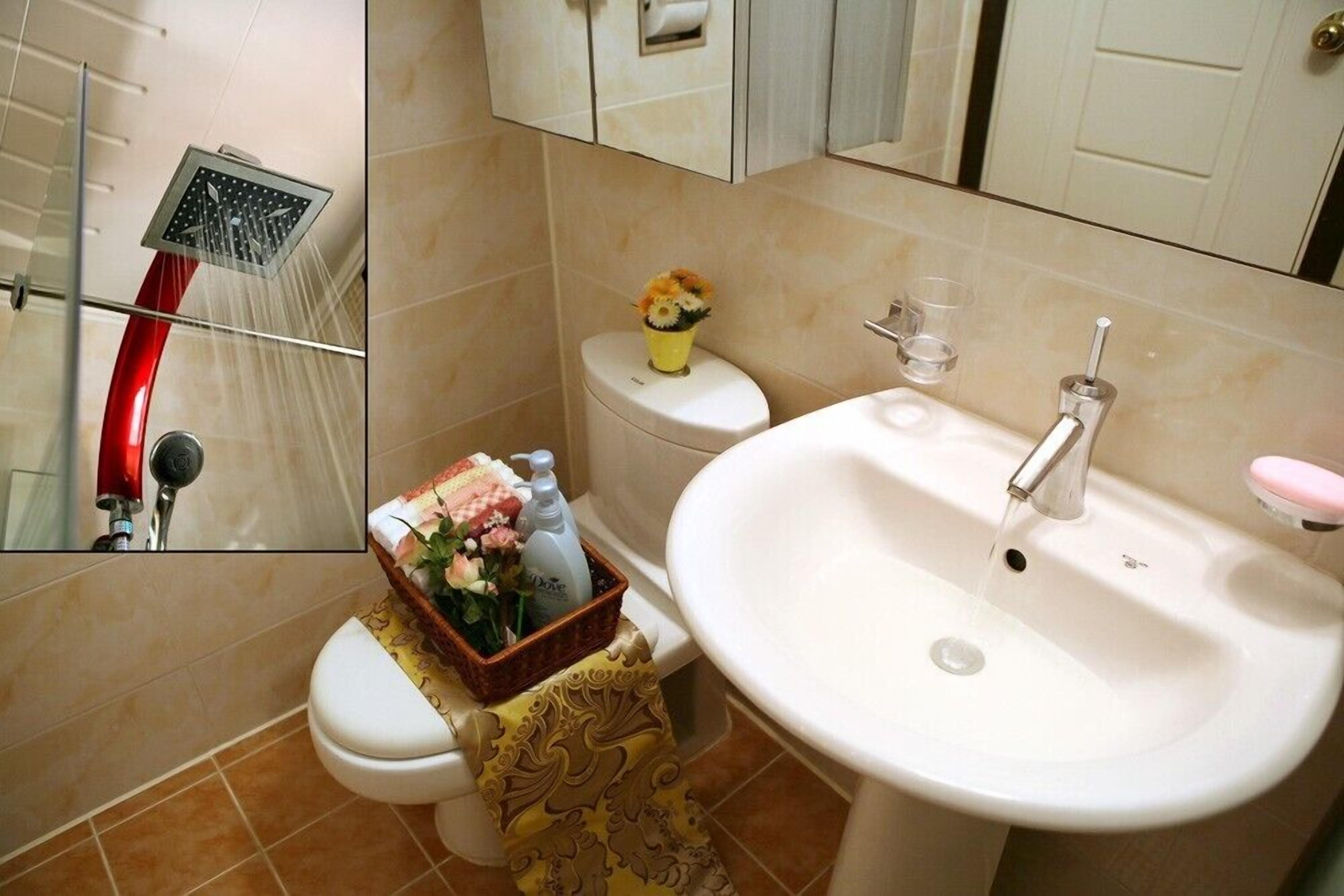 Un baño con ducha, inodoro, lavamanos y espejo.
