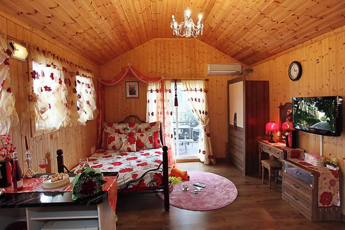 Una habitación acogedora de madera con una cama, un televisor y un comedor.