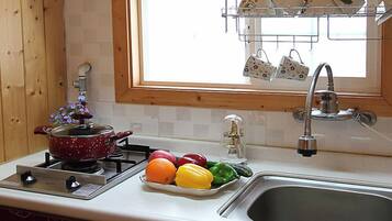 Una cocina con estufa, lavamanos y ventana.