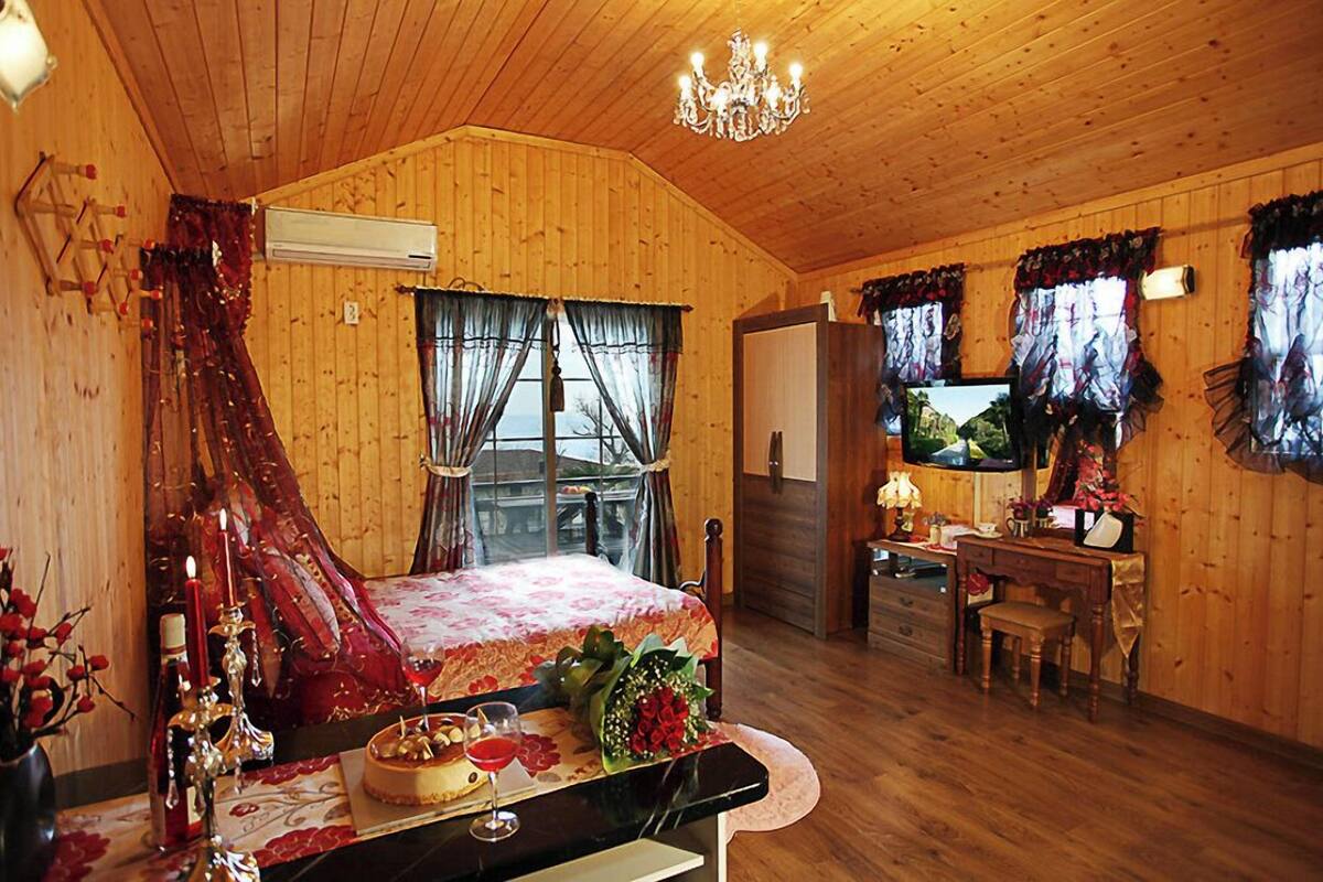 Una cabaña de madera acogedora con una cama, una mesa de comedor y un televisor.