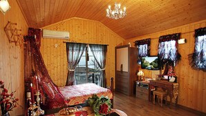 Una cabaña de madera acogedora con una cama, una mesa de comedor y un televisor.