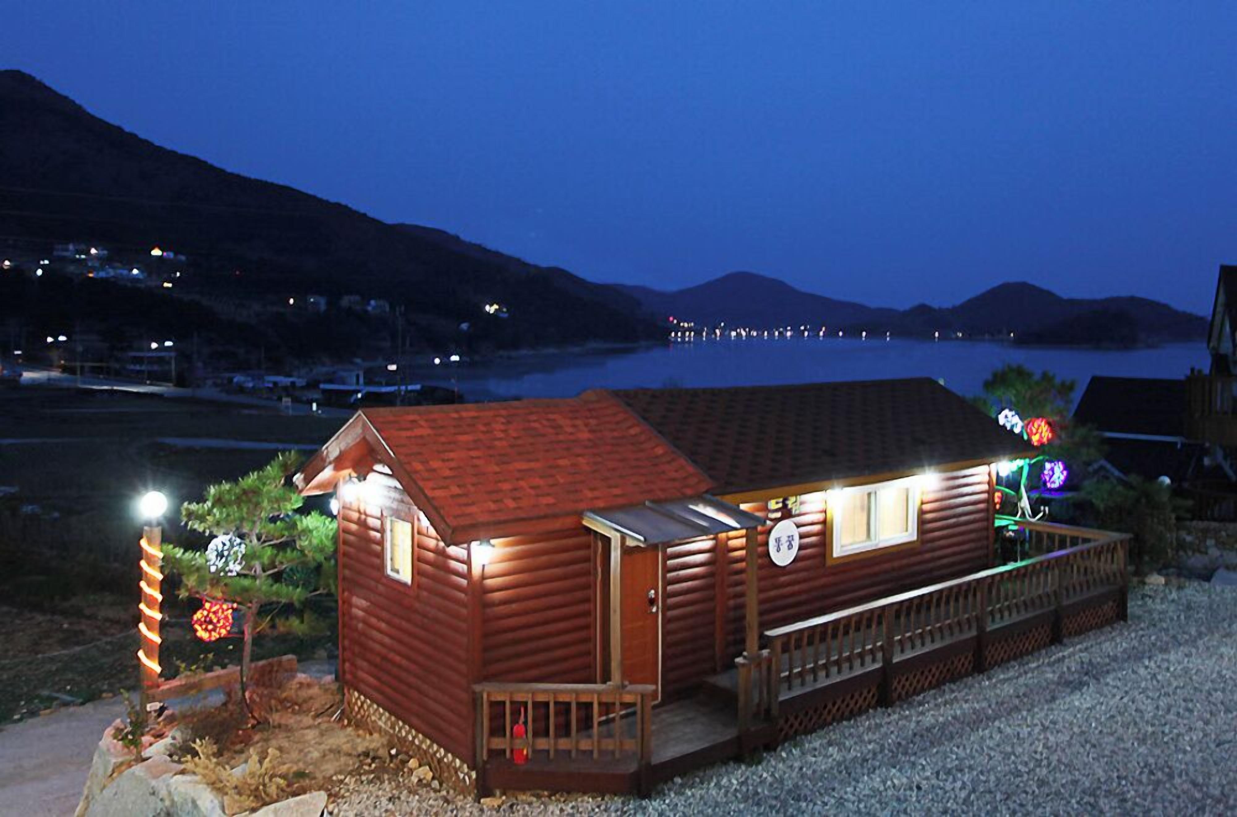 Una cabaña de madera con un porche, una pequeña terraza y un letrero que indica que es un restaurante.