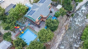 A multi-story building with a swimming pool, solar panels, and a slide. - Utbeodeong Pension (Chuncheon)