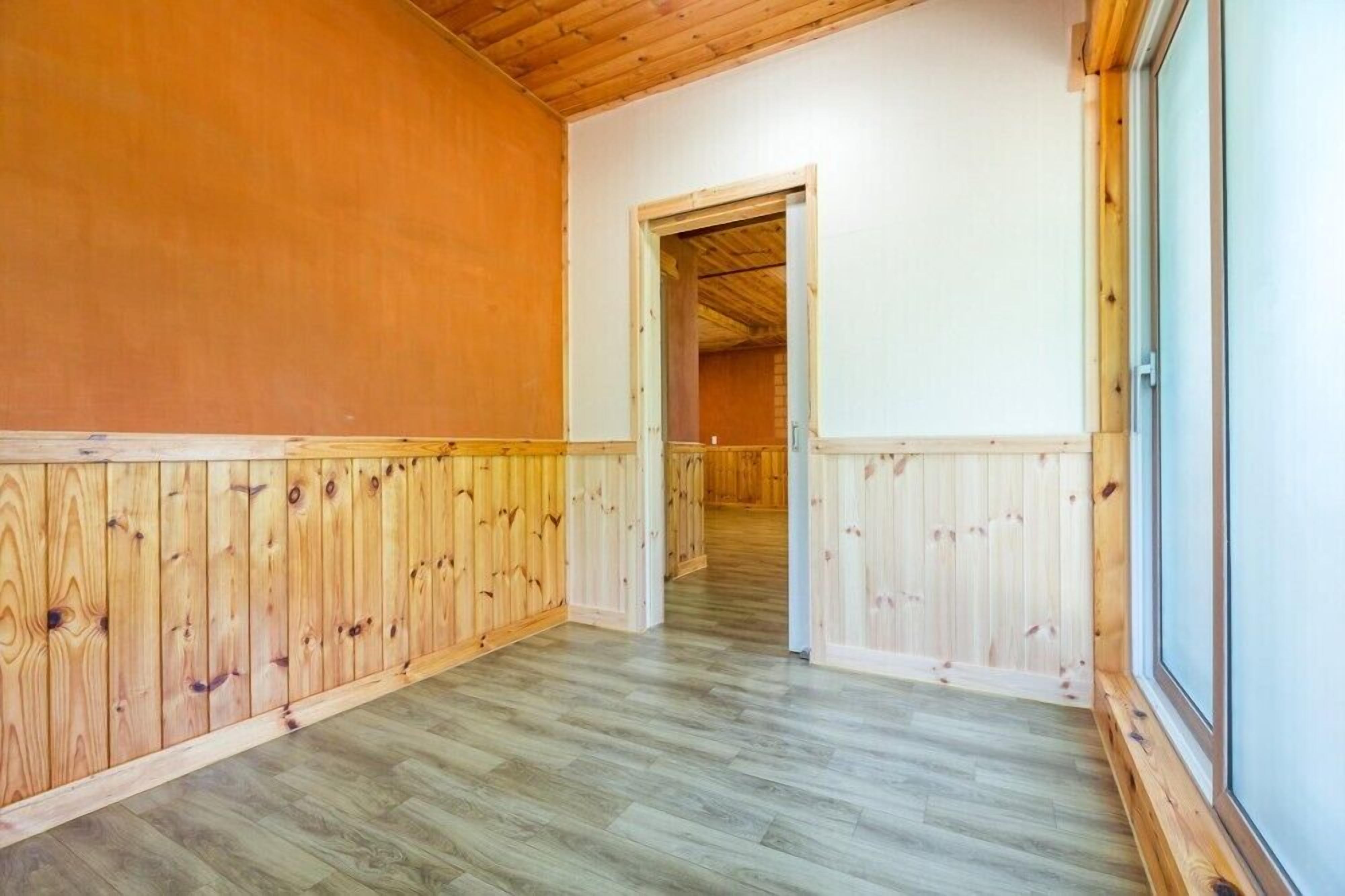 Un pasillo con paneles y techo de madera.