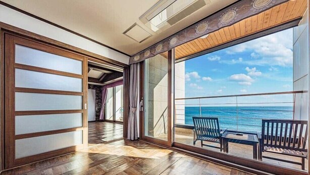 Un balcon spacieux doté d’un plancher en bois et offrant une vue sur l’océan.