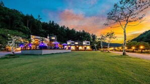 Un resort moderno con varias edificaciones, zonas de estar al aire libre y un césped bien cuidado.