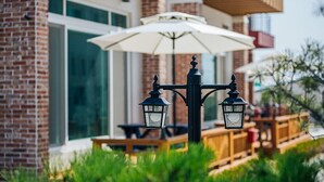 A brick building with a white umbrella and two black lanterns. - Maggiore Pension 1 (Pohang)