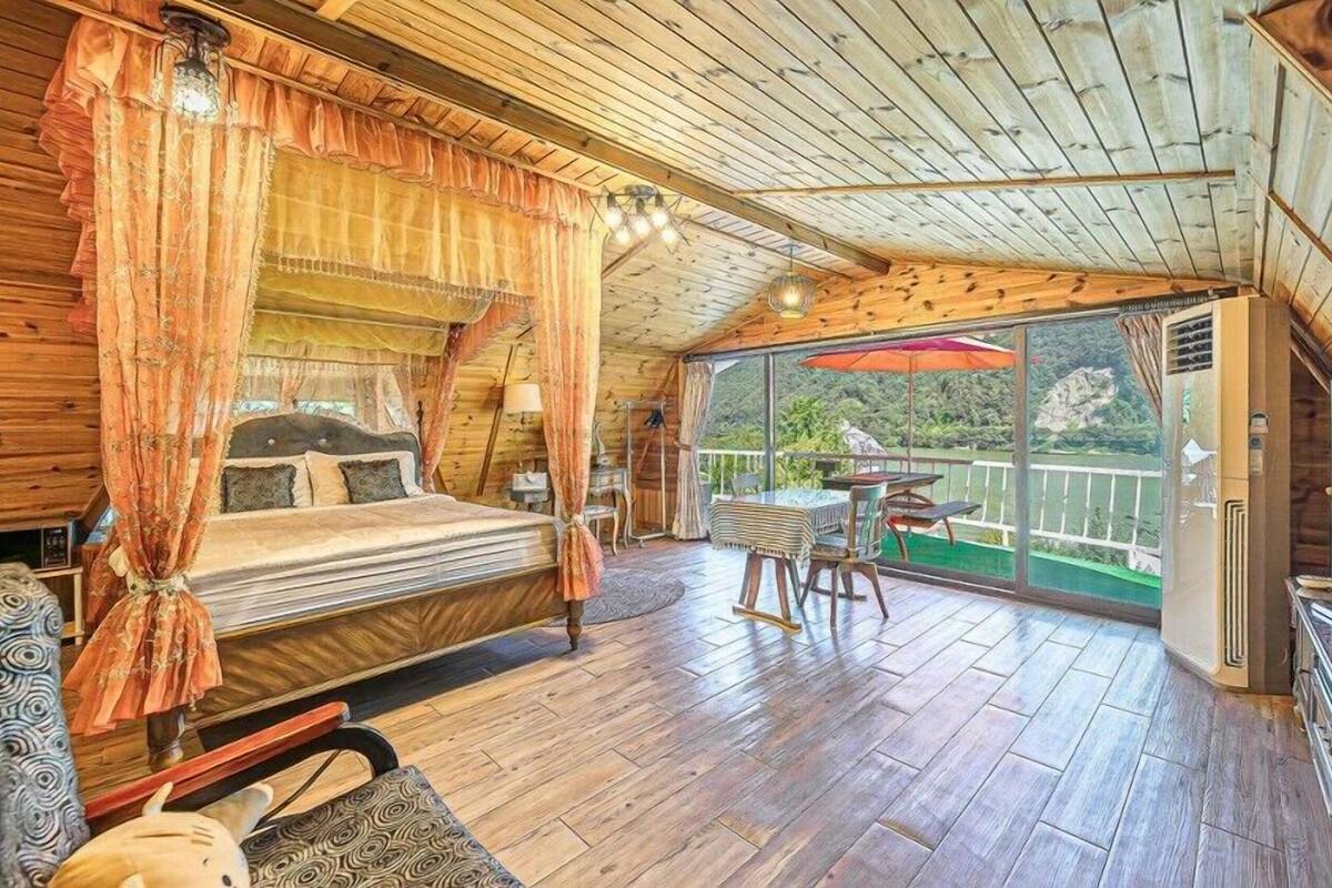 A wooden cabin with a bed, a table, and a TV.