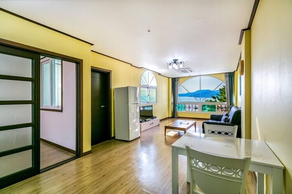 Un espacio habitable compacto con kitchenette, zona de comedor y un amplio ventanal con vistas.