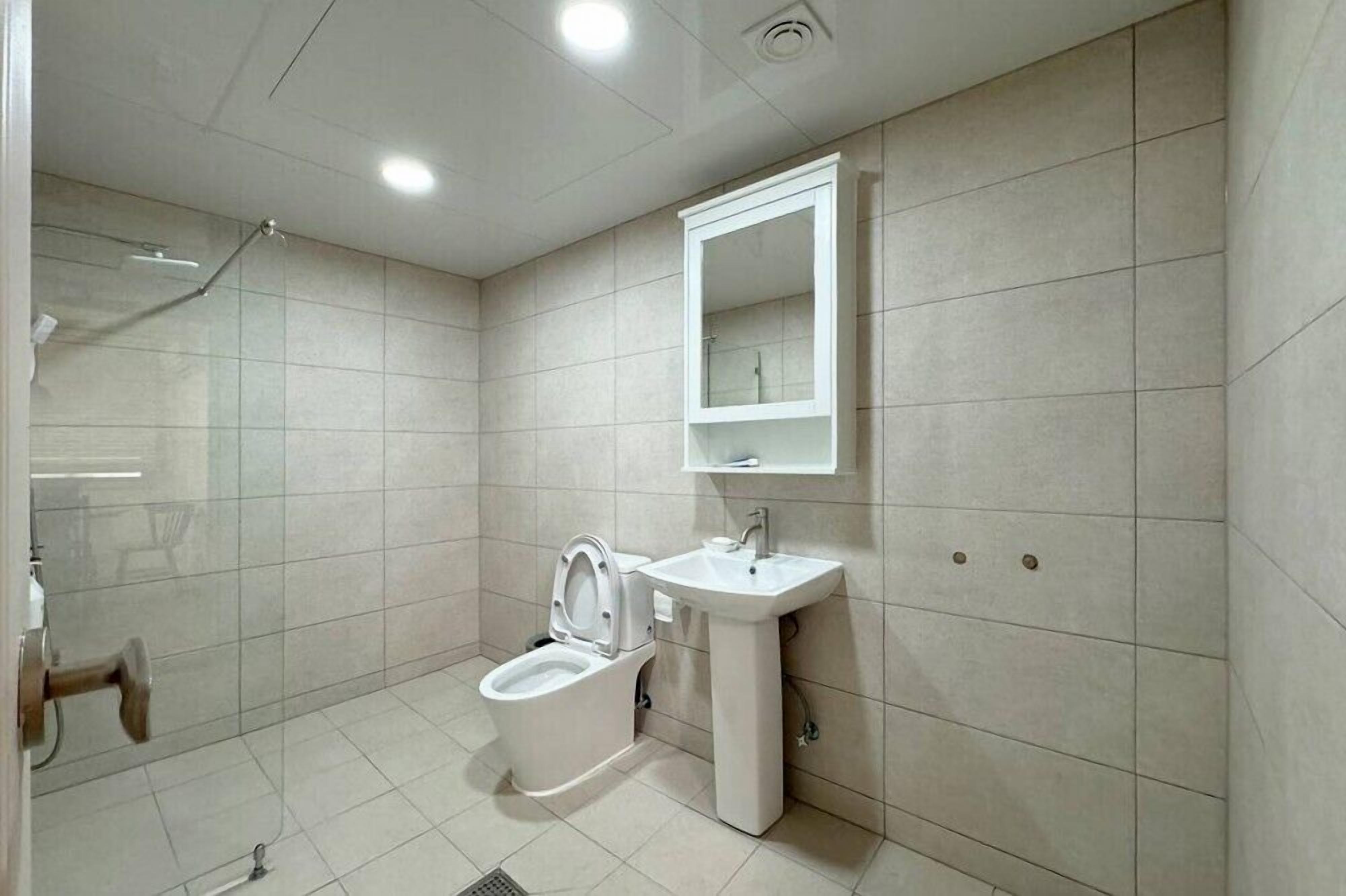A modern bathroom with a toilet, sink, and shower.