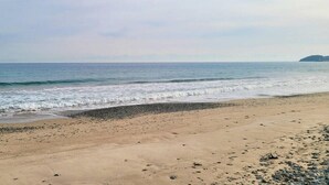 A beach with a pebbly shore and calm waves. - Taeyoung Pension (Pohang)