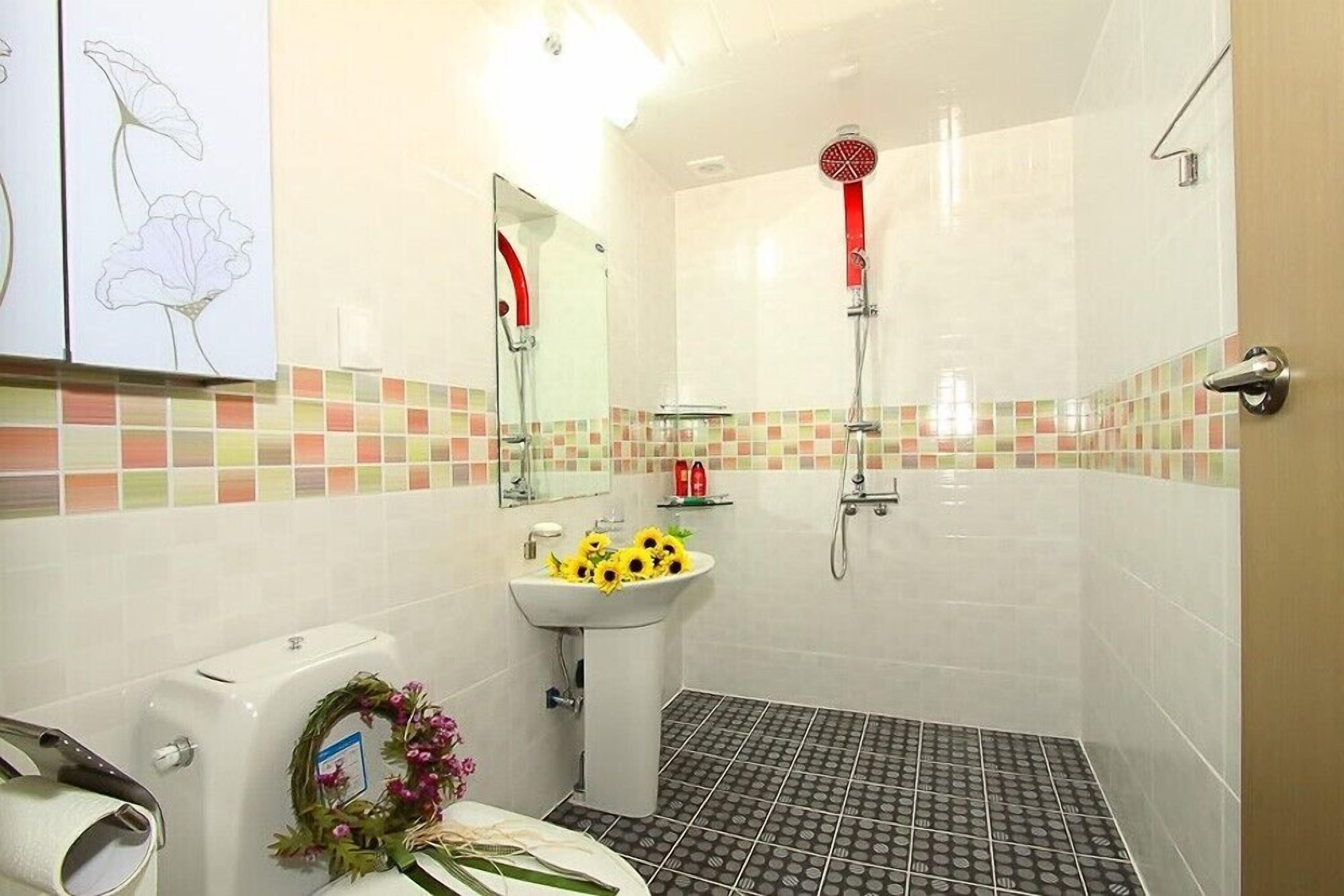 Un baño con inodoro, lavamanos, ducha y espejo.