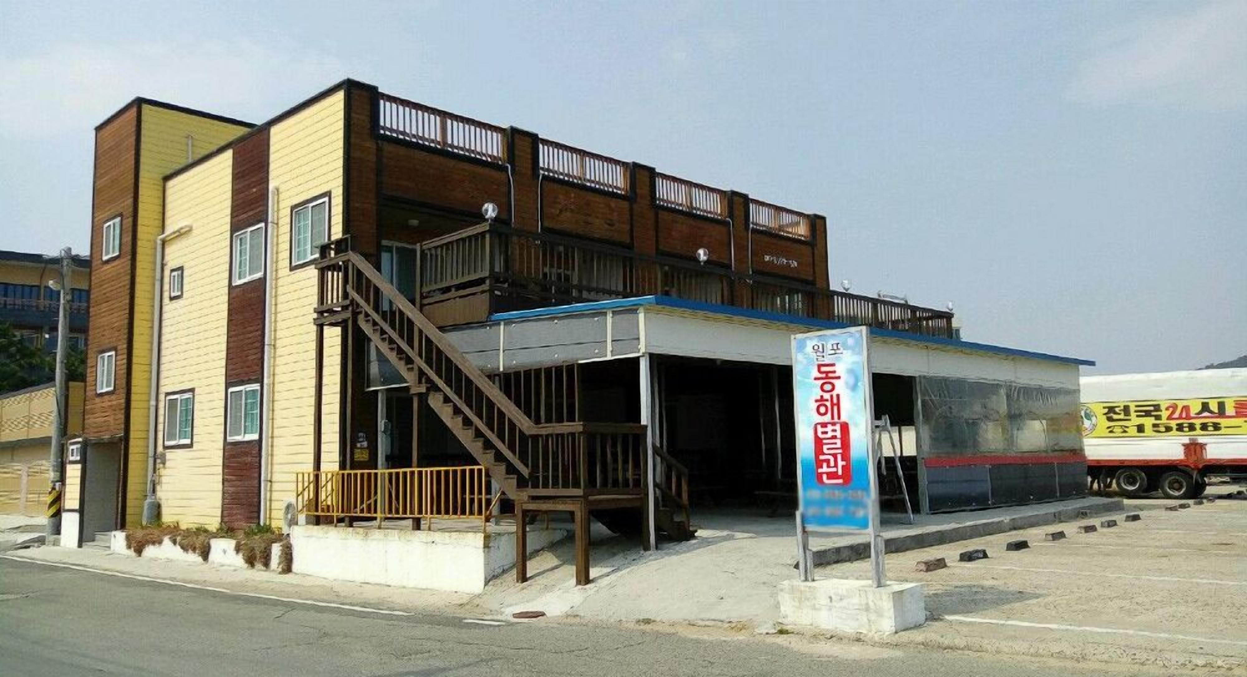 A multi-story building with a covered entrance and a staircase leading to the upper floors.