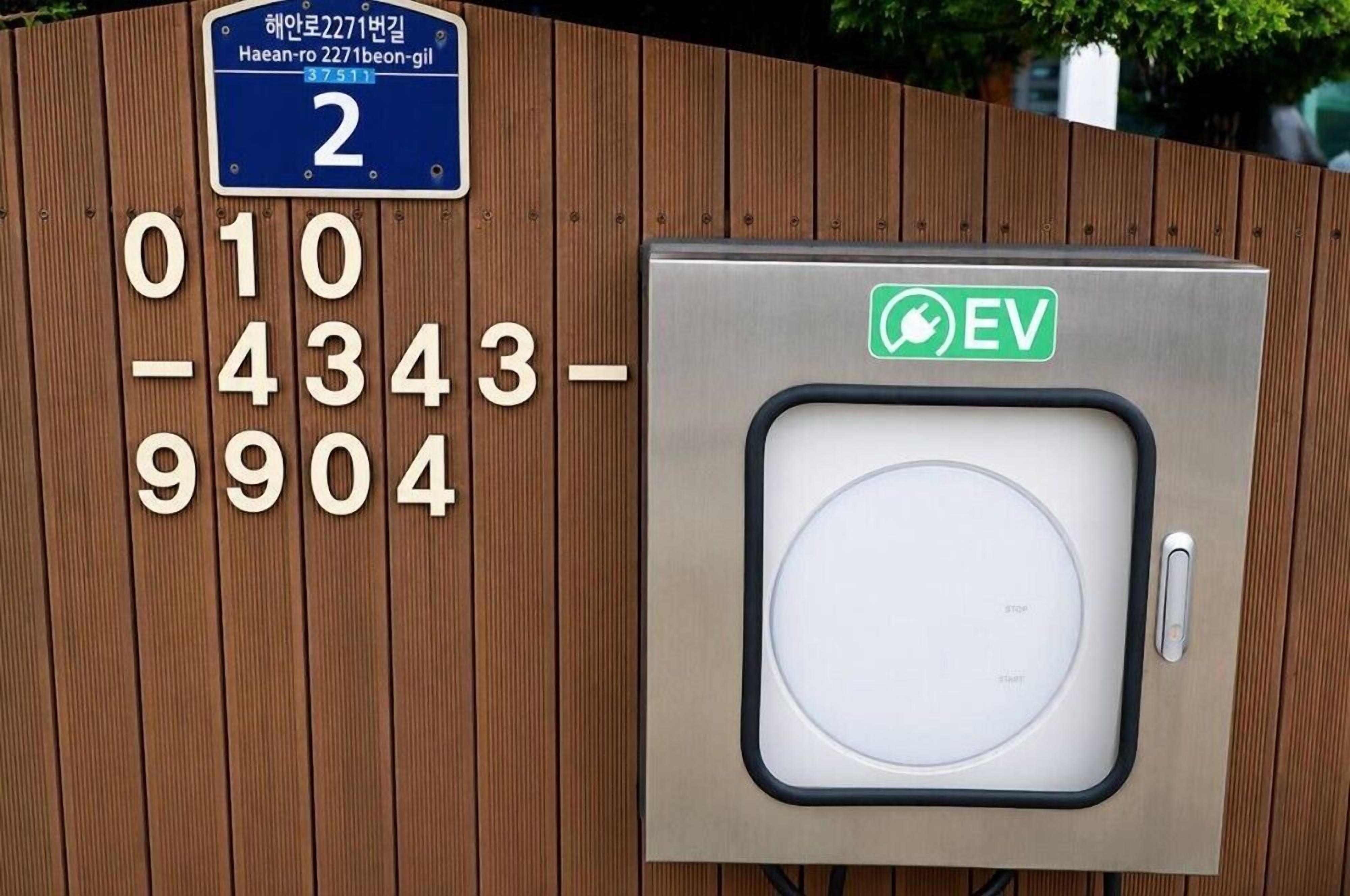 Segnale di parcheggio con numeri e una stazione di ricarica per veicoli elettrici.