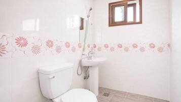 Un baño con inodoro, lavabo y ducha.