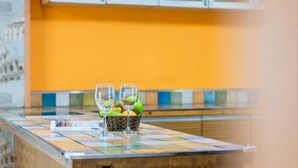 A kitchen counter with a tiled backsplash, a fruit basket, and two glasses. - Serence Pension (Gapyeong)