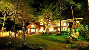 A large, well-lit wooden house with a porch and multiple windows. - Castel on the hill pension (Hoengseong)
